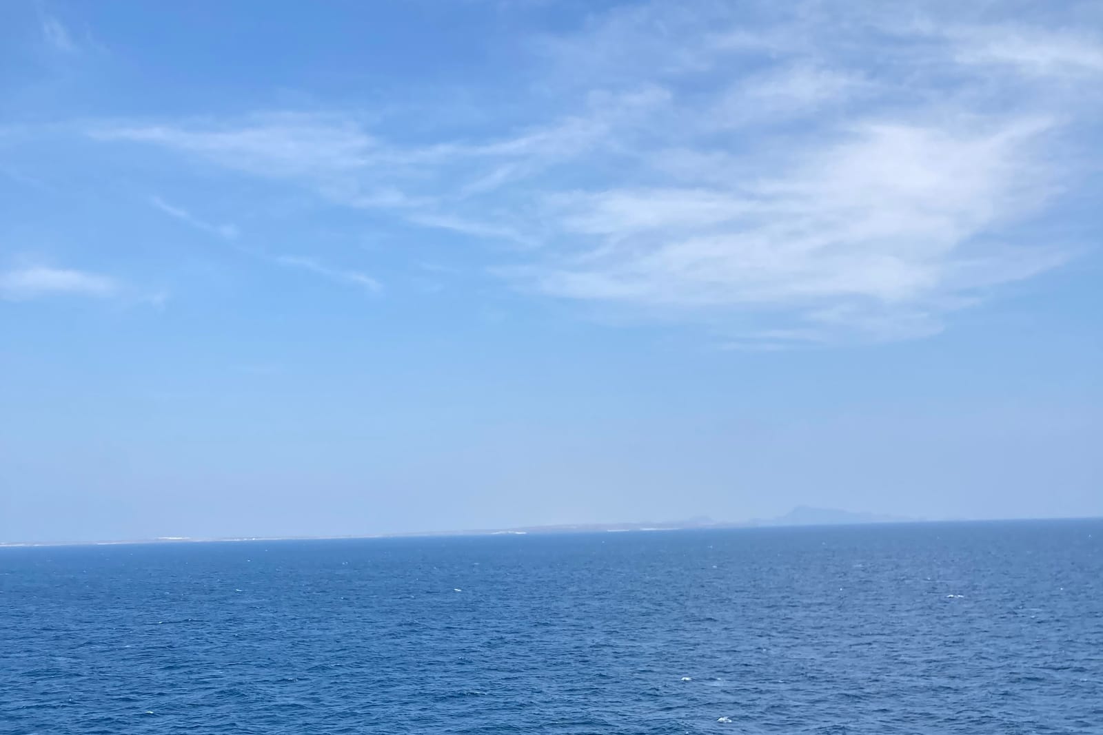 Ground-level photograph of the Bab-el-Mandeb strait from mid-channel, Yemen in the distance and the Djibouti coast just visible the other way.